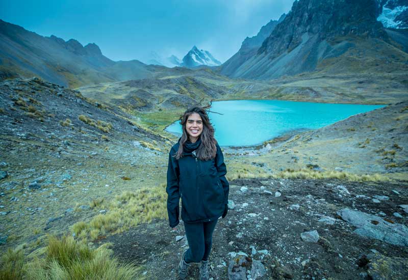 Traveler at a turquoise mountain lake during the Ausangate 7 Lagunas trek in Peru