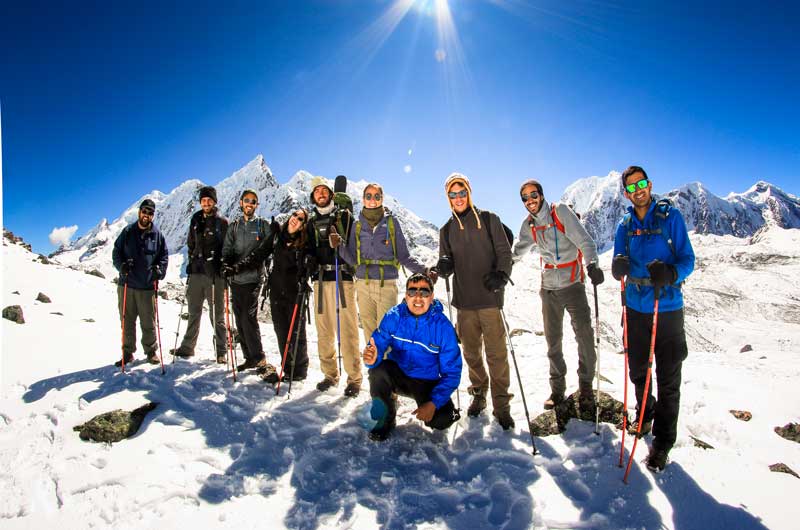 Group of hikers trekking through snow-covered mountains on the Ausangate route in the Peruvian Andes