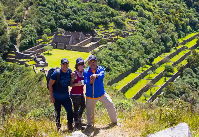 Travelers overlooking the Choquequirao ruins surrounded by lush Andean mountains in Peru