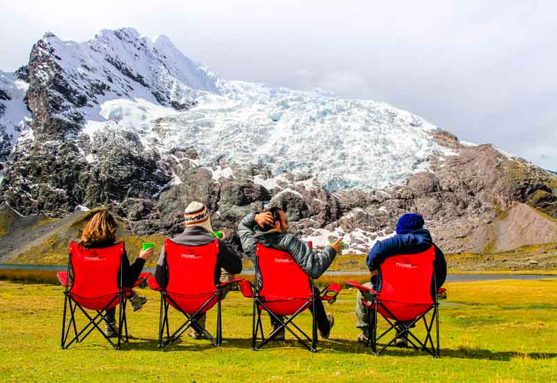 Tourists sitting admiring the Ausangate glacier and mountains