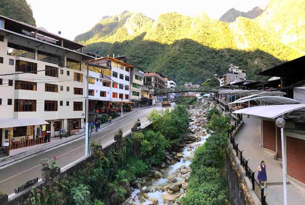 Machu Picchu Pueblo (Aguas Calientes) in Peru with colorful buildings, mountain scenery, train station, and Urubamba River, Experience Peru’s Most Exciting Route to Machu Picchu