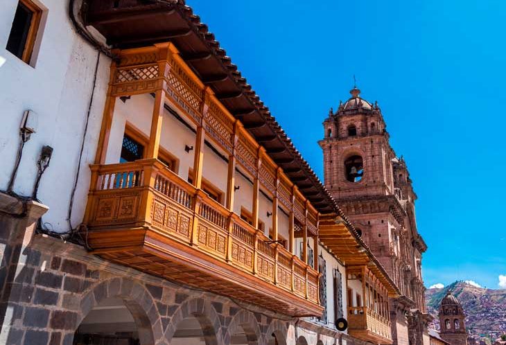 things to do in Cusco, Balconies and the Church of the Society of Jesus in Cusco Peru featuring baroque colonial facade, carved stone details, and historic Plaza de Armas surroundings