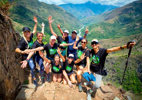 Smiling women enjoying the Inca Jungle Tour on the way to Machu Picchu, surrounded by lush tropical landscapes in Peru.