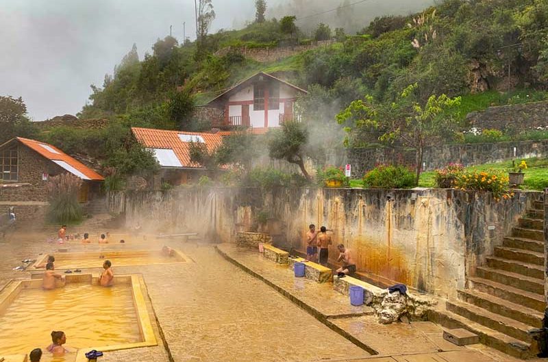 Natural hot springs in Lares with steaming pools surrounded by Andean mountains and rocky landscapes in Peru.