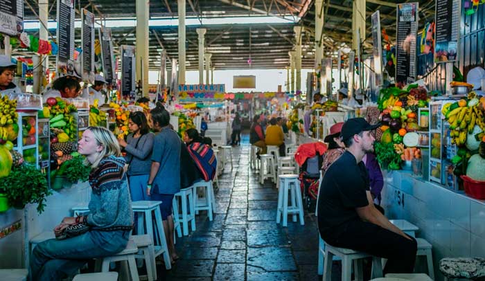 Colorful stalls inside San Pedro Market in Cusco displaying fresh produce, local foods, handicrafts, and traditional products.