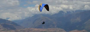 Adventure Tours in the Sacred Valley, Paragliding over the Sacred Valley of the Incas in Peru with mountains, rivers, and Andean landscapes seen from the sky