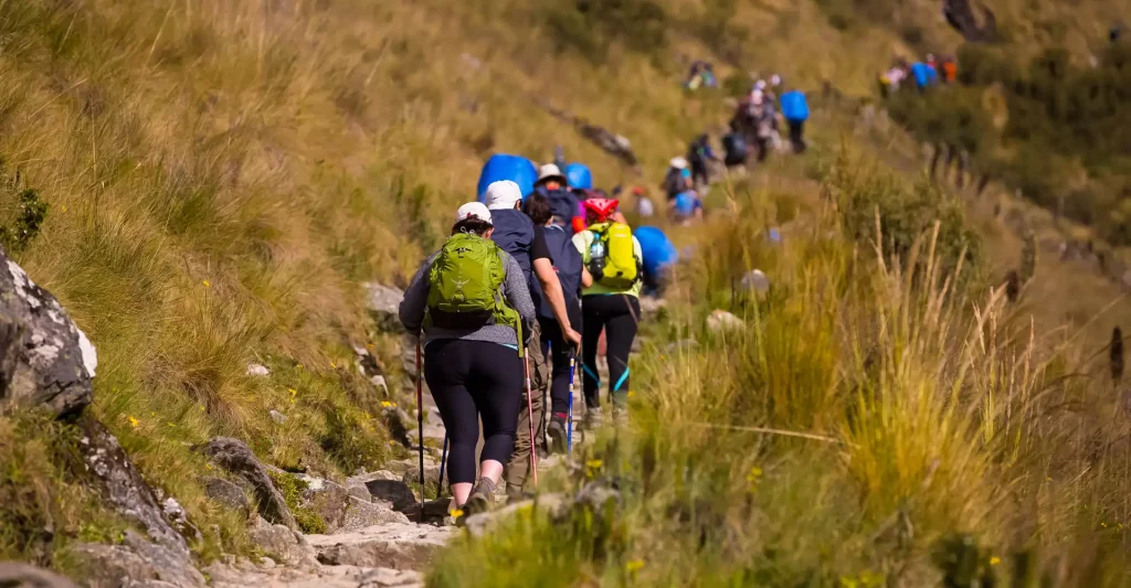 Inca Trail Route Highlands, Inca Trail highlands route in Peru with rugged Andean mountains, stone pathways, and hikers trekking through high-altitude landscape toward Machu Picchu, Inca Trail Permits
