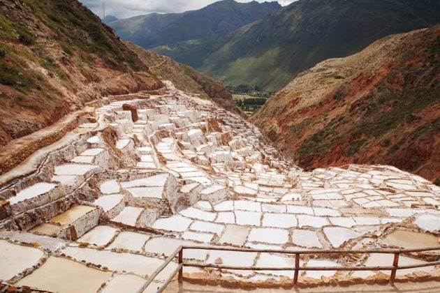 Maras Salt Mines in Peru showing thousands of white salt evaporation pools on a mountainside in the Sacred Valley near Cusco